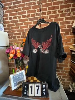 vintage-style graphic t-shirt featuring a motorcycle with red wings